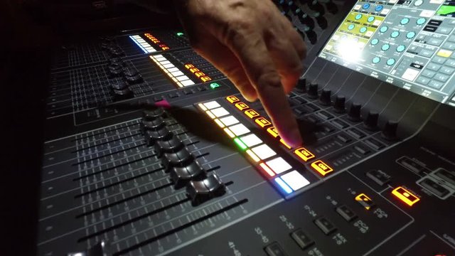 Professional audio mixing console with faders and adjusting knobs - 