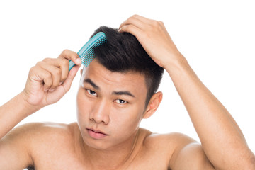Naklejka premium Handsome man brushing hair with comb close up portrait studio on white background