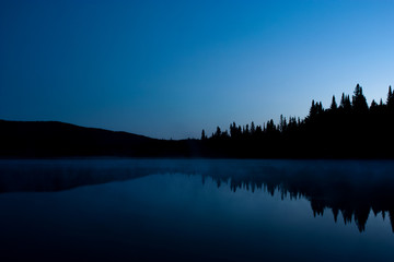nighttime landscape with reflection on a lake