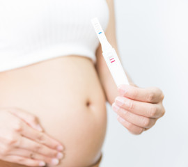Selective focus Pregnancy test positive result, Blurred pregnant holding a result.