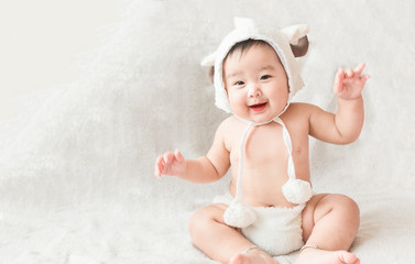 Soft focus Cute Asian male baby sitting on a towel. Blurred background.