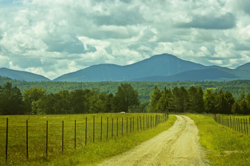 endless road going through the filed into the mountains