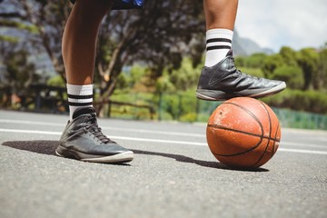 Close up of man standing with one leg on basketball