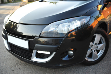 modern car, black hatchback near the fence
