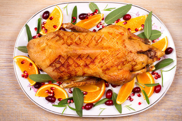 Whole duck with oranges, berries, sage and rosemary. View from above, top studio shot