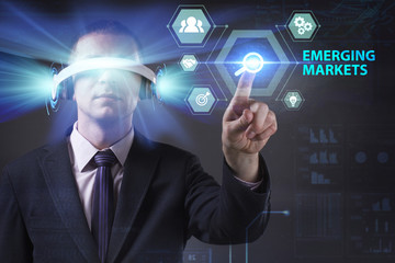 Business, Technology, Internet and network concept. Young businessman working in virtual reality glasses sees the inscription: Emerging markets