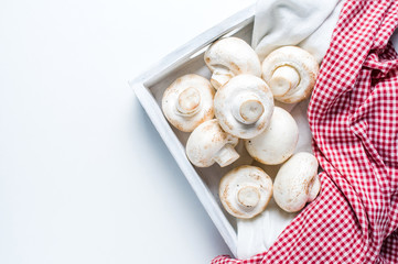 Champignons in a wooden box on a white background