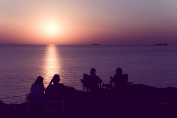 Fototapeta na wymiar Unidentified people wait for sunset at Bozcaada,Turkey