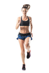 Front view of young pretty female athlete sprinting towards camera. Full body length portrait isolated on white studio background.