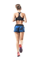 Backside view of fit female jogger jogging movement. Full body length portrait isolated on white studio background.