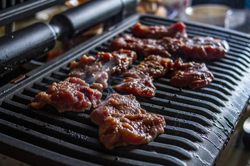 Pieces of fragrant tasty fresh meat with rosemary are roasted on the grill with smoke in the kitchen of the restaurant.