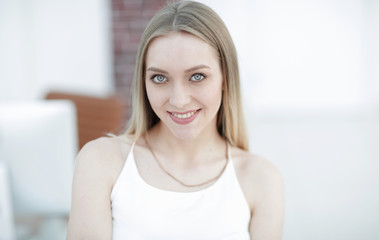 Naklejka premium close-up portrait of a young woman on a blurred office background.