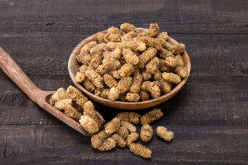 Close Up Shot Of Dried White Mulberries Fruits In A Wooden Bowl And Spoon On Dark Wooden Background, A Healthy And Popular Sweet Snacks In Iran And Turkey
