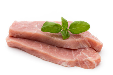 Fresh pork fillet with basil on a white background.