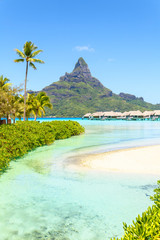 View on Mount Otemanu through turquoise lagoon and overwater bungalows on the tropical island Bora Bora, Tahiti, French Polynesia, Pacific ocean. - obrazy, fototapety, plakaty