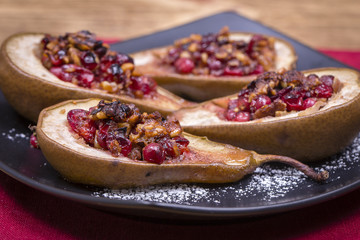 Homemade baked pears with honey, red cranberries and walnuts, close up