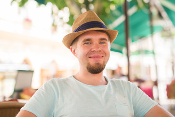 Fototapeta premium Young handsome man sitting in a street cafe.