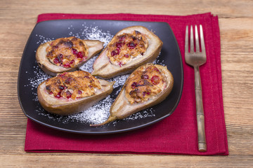 Homemade baked pears with cottage cheese, honey, red cranberries and walnuts, close up