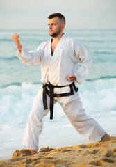 Brunette male practising karate kata poses