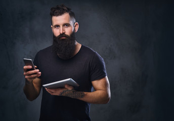 A man holds tablet PC and smartphone.