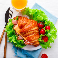 Fresh Croissant Sandwich with  Ham, Cheese,Cherry tomatoes and Salad leaf  with Coffee and a glass of Juice  Breakfast in bed Delicious Baking  Light Meal