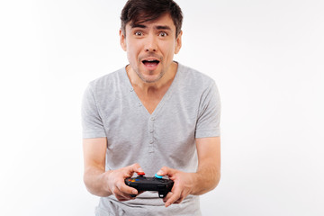 Excited young man playing video game with controller