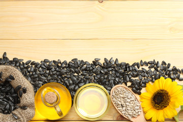 Sunflower oil, seeds and flower on wooden background. top view with copy space