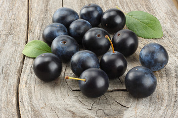 blackthorn berries with green leaf on old wooden table