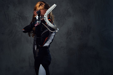 Redhead female Biathlon champion aiming with a competitive gun.