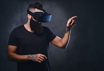 A man with tattoos on arms wearing VR glasses.