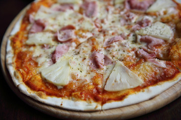 pizza hawaiian , pizza with pineapple and ham with cheese and tomatoes sauce on wood background , italian food