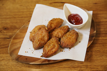 Fried chicken wings on wood background with restaurant light