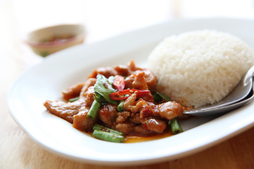 fried pork with thai curry and rice on wood background , Thai food