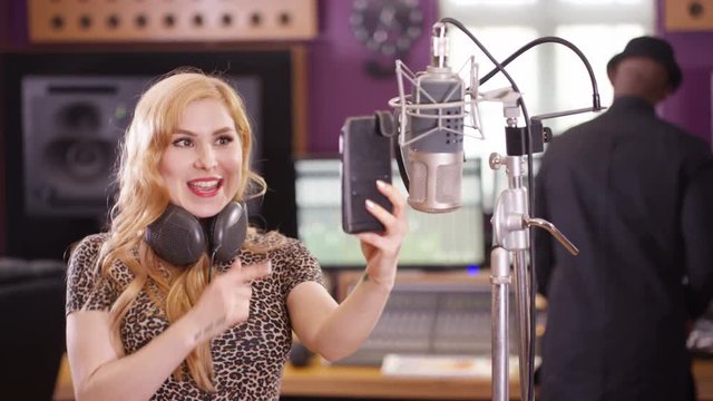  Female vocalist in recording studio using mobile phone for video call