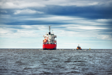 General cargo ship next to a tugboat in a open sea. Klaipeda, Lithuania