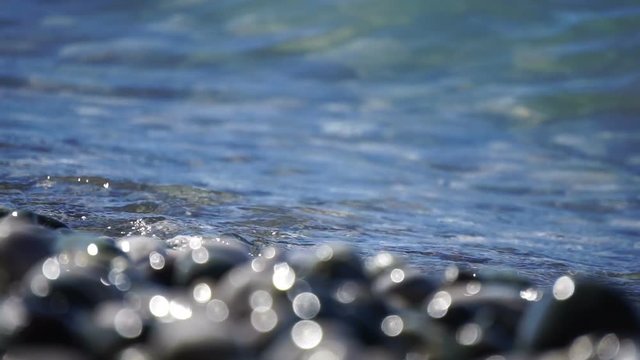 Sea beach of peebles with the foam of the waves in motion