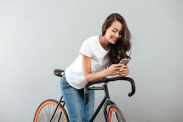 Plakat Happy young caucasian lady sitting on bicycle
