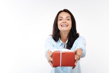 Obraz premium Happy young woman handing a red gift box