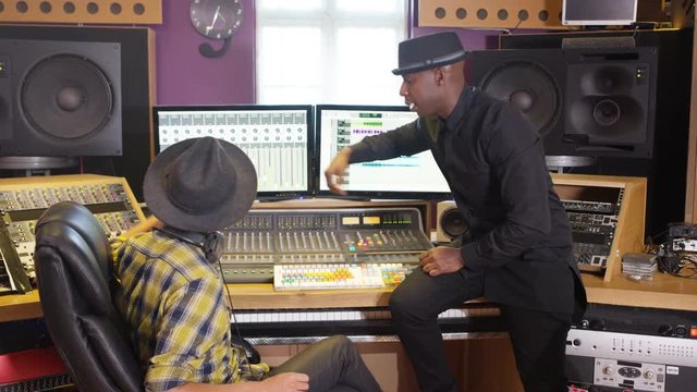  Music producer & sound engineer working together in recording studio