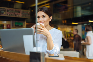 Pretty woman enjoying latte at cafe counter