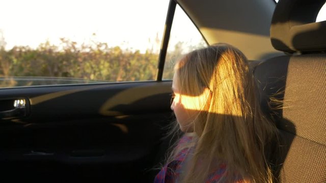 Young white girl sitting in car and jumping jolting on bumps. Slow motion close up handheld shot.