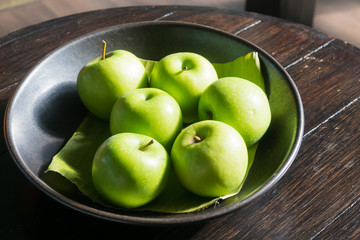 Six green apples on table