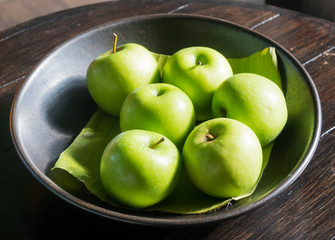 Six green apples on table