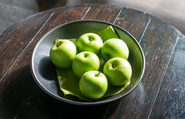 Six green apples on table