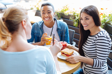 Three upbeat women telling jokes during lunch