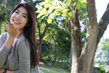 asian woman portrait. young female adult with natural make-up relax in park. attractive teenager smile with happiness in garden