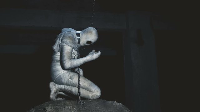 people being in bandages in a dark, abandoned building on the chain in custody