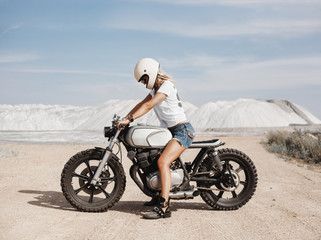 Naklejka premium Kobieta na niestandardowym motocyklu cafe racer