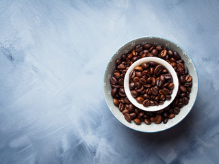 Whole Coffee beans in bowl on blue background