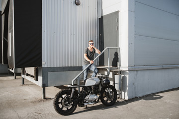 Rider guy with classic style cafe racer motorcycle